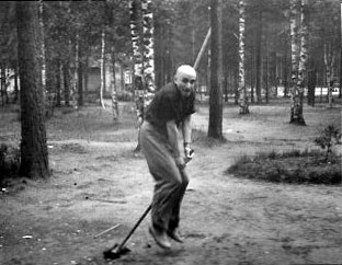 «На метле», шуточная фотография Михаила Вержбинского на фоне леса, где он скачет на метле